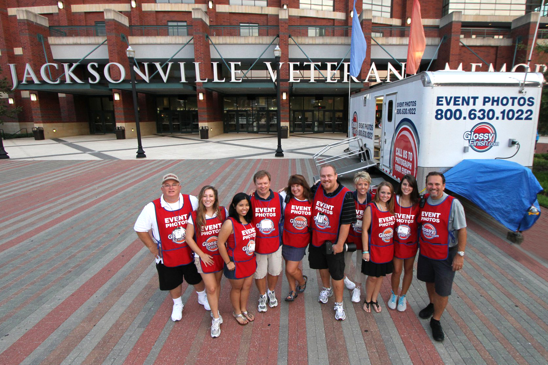 Group photo of the Glossy Finish team standing in front of their mobile photo lab.
