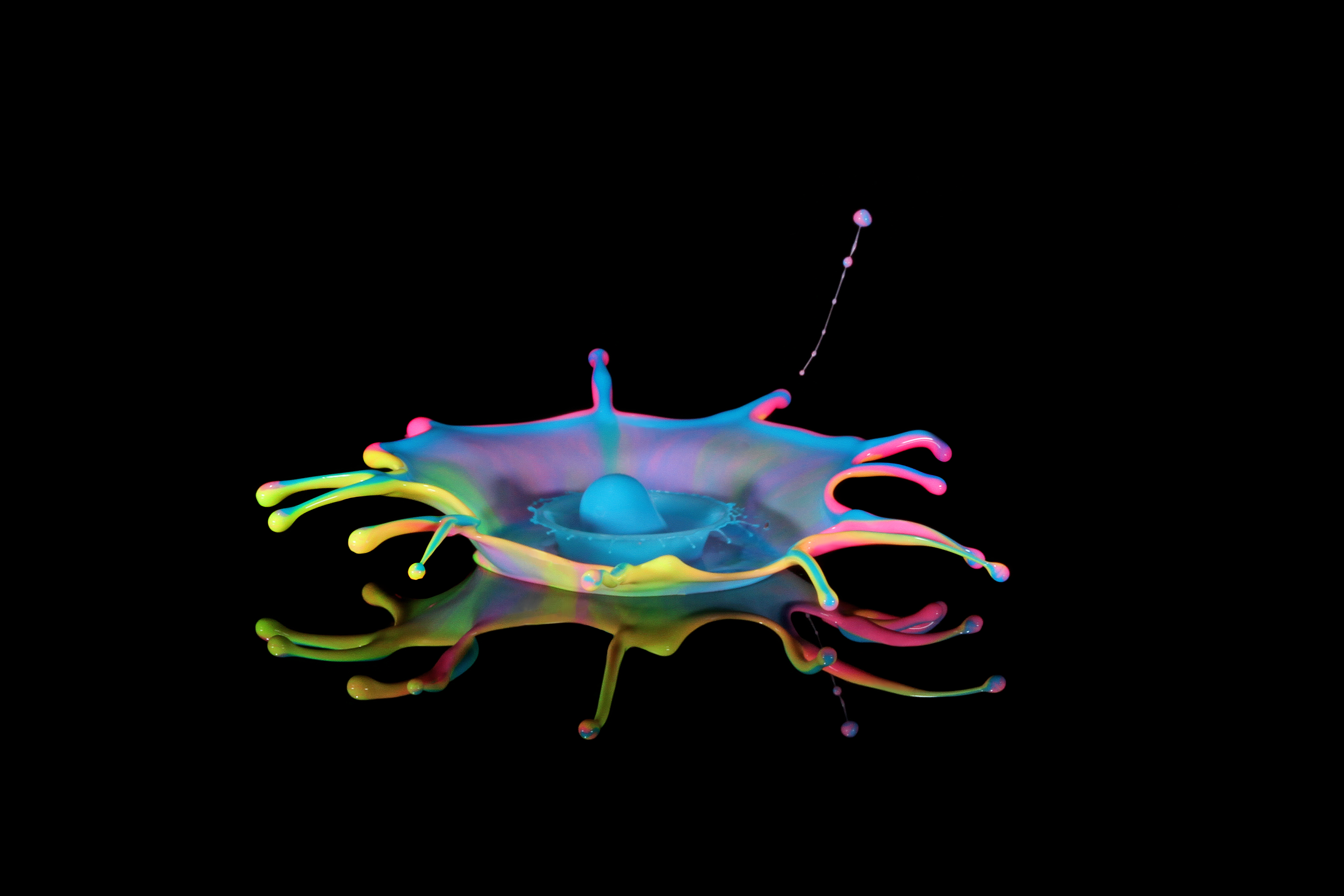 Multicolored water-drop crown splash on a black background.