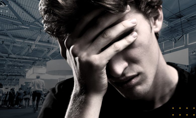 Photo of a disappointed young man with his hand over his eyes.