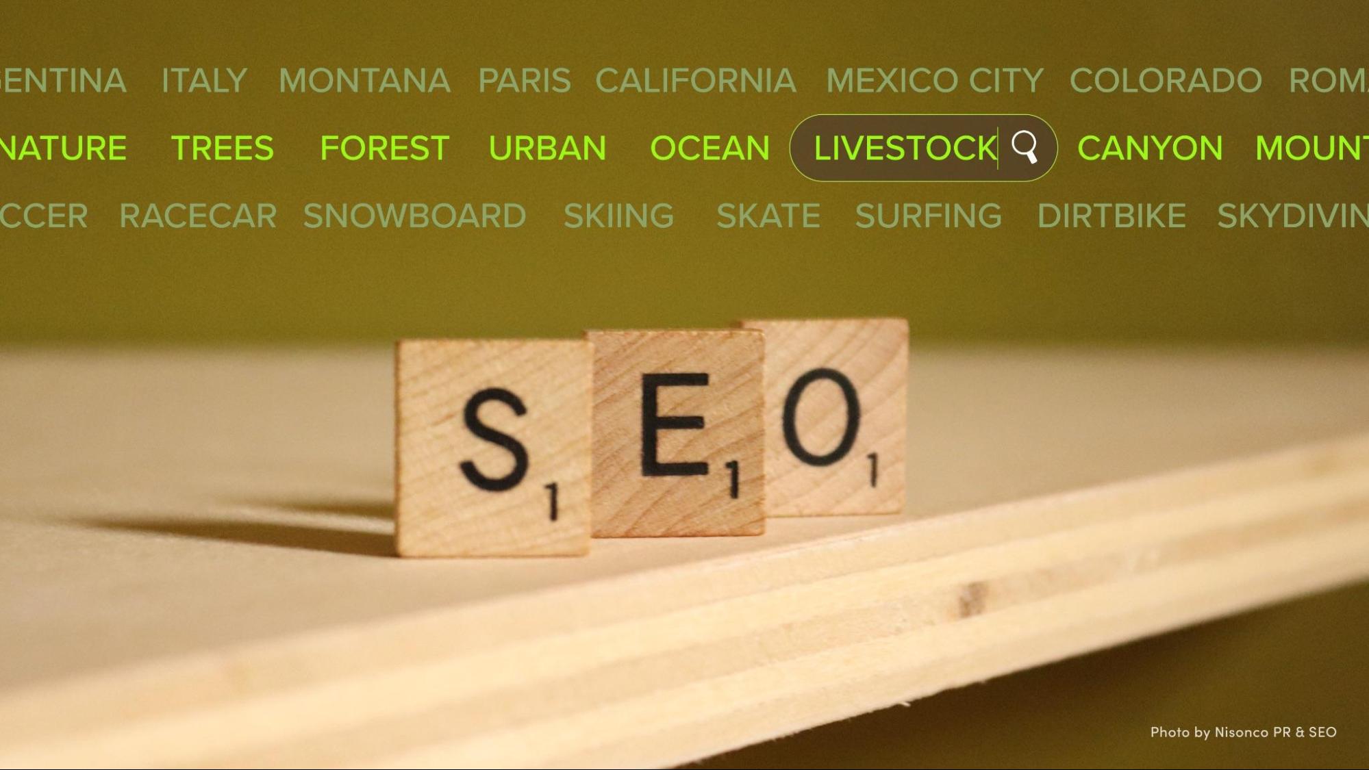 Scrabble tile letters S-E-O set up along a table's edge with a list of search terms above them.