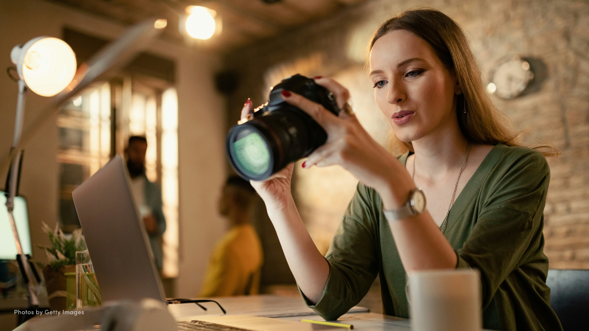 Woman sitting in a café and looking at the LCD screen of her DSLR camera.
